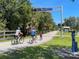 Scenic view of the Legacy Trail with cyclists enjoying the paved path amidst lush greenery and a clear blue sky at 13908 Vadini St, Venice, FL 34293