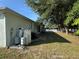 The expansive backyard features mature trees and equipment for the home's water system at 1483 Prairie Ter, North Port, FL 34286