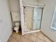 Bathroom with a toilet, storage cabinet, and a shower with sliding glass doors at 1483 Prairie Ter, North Port, FL 34286