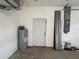 Spacious garage with a water heater, electrical panel, and access door at 1483 Prairie Ter, North Port, FL 34286