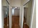Hallway featuring mirrored closet doors, leading to the bedroom, enhancing space and light at 1483 Prairie Ter, North Port, FL 34286