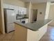 Kitchen featuring white appliances, cabinets, and a breakfast bar with tiled floors at 1483 Prairie Ter, North Port, FL 34286