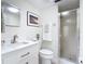 Bright bathroom featuring a glass shower, modern vanity with white countertops, and decorative wall art at 1730 Manasota Beach Rd # 212, Englewood, FL 34223