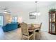 Open dining room features light wood floors, views of the living room, and chandelier at 1730 Manasota Beach Rd # 212, Englewood, FL 34223