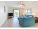 Bright living room features light wood floors, comfortable seating, and sliding glass doors to the balcony at 1730 Manasota Beach Rd # 212, Englewood, FL 34223