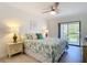 Relaxing main bedroom featuring a ceiling fan and a private balcony at 1730 Manasota Beach Rd # 212, Englewood, FL 34223