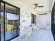Relaxing screened patio with outdoor seating, ceiling fan, and sliding glass doors to bring the outside in at 1730 Manasota Beach Rd # 212, Englewood, FL 34223