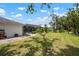 Spacious backyard with a screened-in pool area, lush green lawn, and well-maintained landscaping at 1833 Raintree Ln, Venice, FL 34293