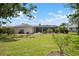 Expansive backyard featuring a screened-in pool, patio area, lush lawn and mature landscaping at 1833 Raintree Ln, Venice, FL 34293