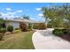 Beautiful single story home featuring a circular driveway, lush landscaping, and a well maintained lawn at 1833 Raintree Ln, Venice, FL 34293