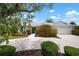 Charming home exterior with lush landscaping, mature trees, and a well-maintained driveway at 1833 Raintree Ln, Venice, FL 34293