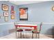 Quaint eat-in kitchen with vintage table set, decorated with art, and bright blue walls at 1833 Raintree Ln, Venice, FL 34293