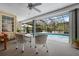 Relaxing screened-in lanai overlooking a sparkling pool and lush landscaping, perfect for outdoor enjoyment at 1833 Raintree Ln, Venice, FL 34293