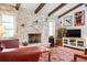 Living room with a stone fireplace, beamed ceilings, and a TV at 1833 Raintree Ln, Venice, FL 34293