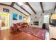 Cozy living room with wood floors, vaulted ceilings with wood beams, and stone fireplace at 1833 Raintree Ln, Venice, FL 34293