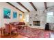 Inviting living room features a stone fireplace, wood floors, beamed ceilings, and stylish decor at 1833 Raintree Ln, Venice, FL 34293