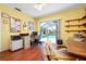 Bright office space with wood floors, and desk setup, featuring sliding glass doors to the screened-in pool area at 1833 Raintree Ln, Venice, FL 34293