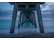 Low angle view beneath the pier showcasing the supporting pillars and tranquil sea at 1833 Raintree Ln, Venice, FL 34293