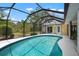 In-ground pool with screened-in lanai provides a picturesque backyard with serene views and access to the home at 1833 Raintree Ln, Venice, FL 34293