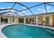 Beautiful pool with screened-in enclosure offers serene views of the home's exterior and access to outdoor lounging at 1833 Raintree Ln, Venice, FL 34293