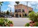 A charming street view of a building with a peach facade and bright pink, yellow and white flowers at 1833 Raintree Ln, Venice, FL 34293