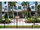 A serene street view showcasing green landscaping, flowers, palm trees, and an inviting building at 1833 Raintree Ln, Venice, FL 34293