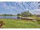 Scenic backyard view features a serene lake, lush greenery, mature trees and idyllic surroundings at 1892 San Silvestro Dr, Venice, FL 34285