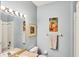 Bathroom features a vanity with large mirror, tub/shower, and beach-themed artwork at 1892 San Silvestro Dr, Venice, FL 34285
