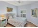 Cozy bedroom featuring a queen bed with floral bedding, shuttered windows, and tile flooring at 1892 San Silvestro Dr, Venice, FL 34285