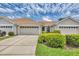 Exterior view of home's garage, landscaping, and driveway on a sunny day at 1892 San Silvestro Dr, Venice, FL 34285