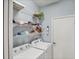 Bright laundry room with shelving and blue walls at 1892 San Silvestro Dr, Venice, FL 34285