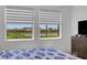 This bedroom features white walls and tile floors as well as a scenic pond view at 19337 Cruise Dr, Venice, FL 34292