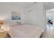Bedroom showcasing a pink bedspread, neutral walls, a closet, and a view into an adjacent office space at 19337 Cruise Dr, Venice, FL 34292
