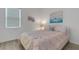 Bright bedroom featuring neutral walls, a pink bedspread, light wood floors, and a window with horizontal blinds at 19337 Cruise Dr, Venice, FL 34292