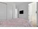 Bedroom exhibiting closet, TV, with view into an adjoining room, and a pink bedspread at 19337 Cruise Dr, Venice, FL 34292