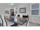 Elegant dining room with a glossy table, white chairs, modern light fixture, and large windows at 19337 Cruise Dr, Venice, FL 34292