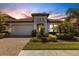 Inviting home with manicured lawn, lush landscaping, and a charming tile roof at 19337 Cruise Dr, Venice, FL 34292