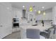 Modern white kitchen with a stainless steel hood, built-in oven, and island with counter seating at 19337 Cruise Dr, Venice, FL 34292