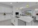 Bright, open kitchen with white cabinetry, marble countertops, island, and modern stainless steel appliances at 19337 Cruise Dr, Venice, FL 34292