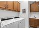 Laundry room with washer, dryer, and wooden cabinets at 19337 Cruise Dr, Venice, FL 34292