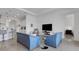 Bright living room with blue sofas, modern furnishings, and a view into the kitchen and dining areas at 19337 Cruise Dr, Venice, FL 34292