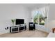 Inviting living room with a modern entertainment center and views of the tropical landscape at 19337 Cruise Dr, Venice, FL 34292