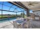 Outdoor patio with a dining table next to a pool with lake views and an outdoor kitchen at 19337 Cruise Dr, Venice, FL 34292