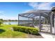 Screened-in lanai with pool and outdoor seating overlooking a picturesque lake in a residential neighborhood at 19337 Cruise Dr, Venice, FL 34292