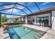Swimming pool with a fountain surrounded by a screen enclosure, table and chairs, and an outdoor grill at 19337 Cruise Dr, Venice, FL 34292