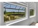 This window view showcases the screened-in pool with a lovely pond view at 19337 Cruise Dr, Venice, FL 34292