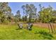 Large, grassy backyard with a fire pit and Adirondack chairs at 2032 Jagust Rd, North Port, FL 34288