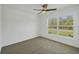 Empty bedroom features neutral carpet, ceiling fan, and large window with a view at 2032 Jagust Rd, North Port, FL 34288