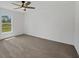 Unstaged bedroom with neutral carpet, a ceiling fan, and a large window overlooking the yard at 2032 Jagust Rd, North Port, FL 34288