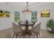 Inviting dining area featuring natural light, a modern chandelier, and stylish decor at 2032 Jagust Rd, North Port, FL 34288